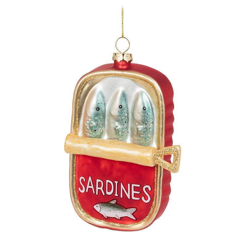 Decorative ornament shaped like a can of sardines with glass sardines inside on a white background.