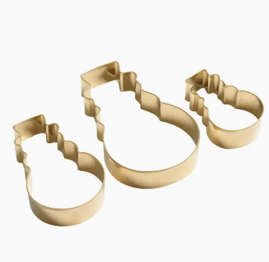 Set of three gold cookie cutters shaped like animals on a white background