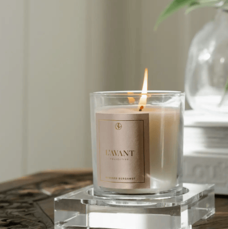 Candle with a label on a clear stand, with a neutral background