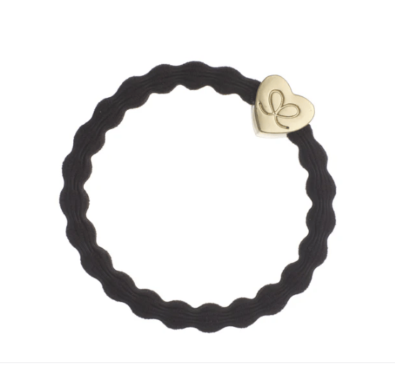 Black hair tie with a gold heart-shaped tag on a white background