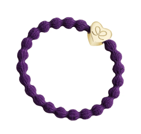 Purple hair tie with a gold heart-shaped charm on a white background