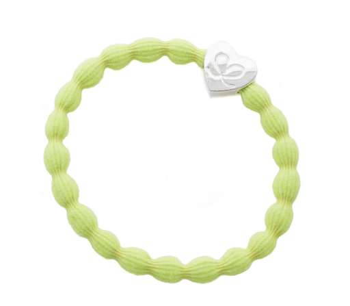 Light green textured ring with a silver heart-shaped charm on a white background