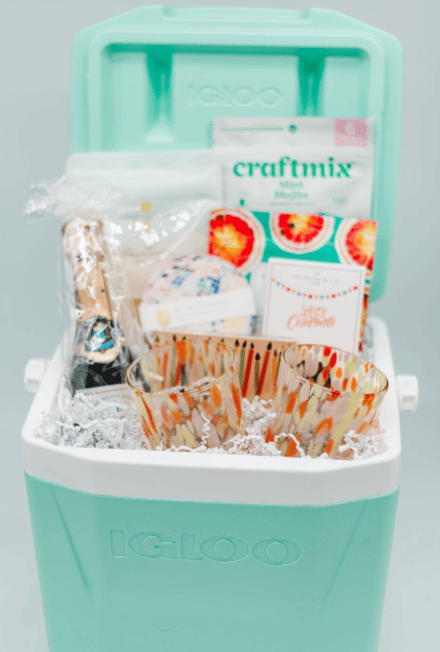 Teal cooler with snacks and drinks on a gray background