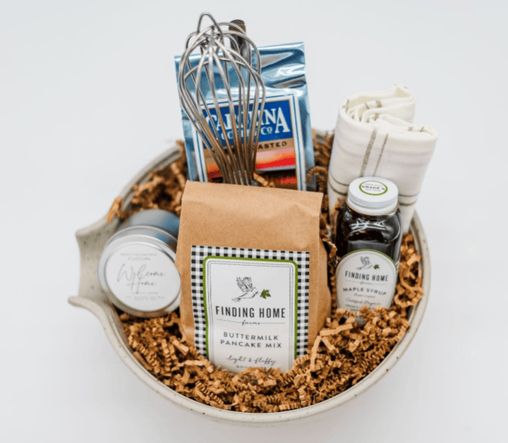 Gift basket with pancake mix, syrup, and other items on a white background
