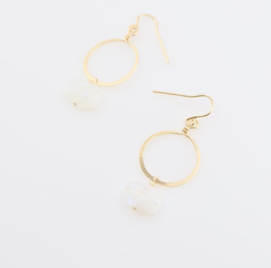 Gold hoop earrings with a moonstone drop on a light gray background