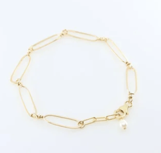 Forged gold paperclip link bracelet with pearl accent on a white background