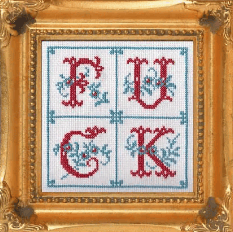 Cross-stitched design with red letters 'F', 'U', 'C', 'K' on a white background, framed in gold.