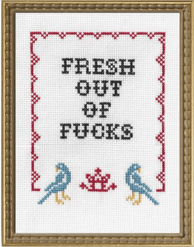 Cross-stitched design with text 'FRESH OUT OF FUCKS' and decorative elements on a white background.