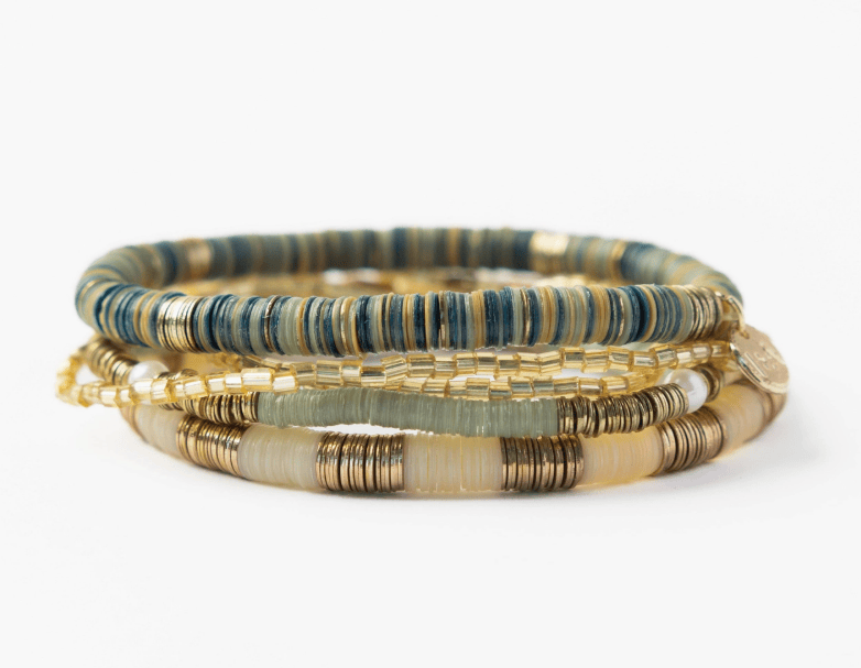 Set of three beaded bracelets in gold, green, and brown on a white background