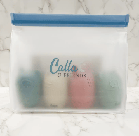 Clear pouch with blue lid containing cylindrical items on a marble surface, branded 'Calla & Friends'.