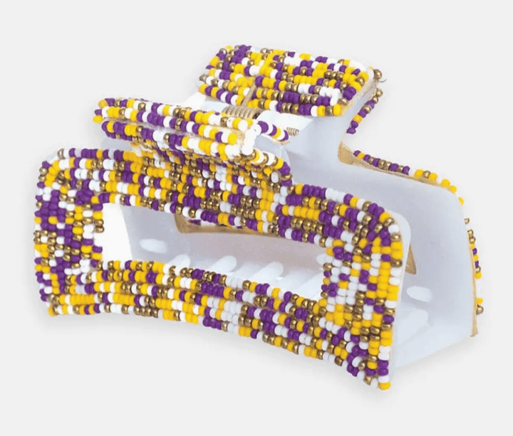 Claw hair clip with purple and gold beaded design on a white background