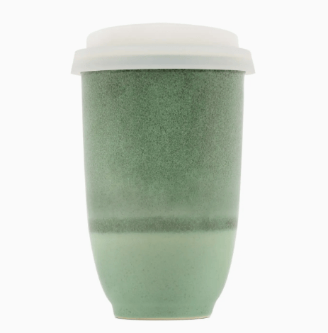 Green textured ceramic cup with a white lid on a white background