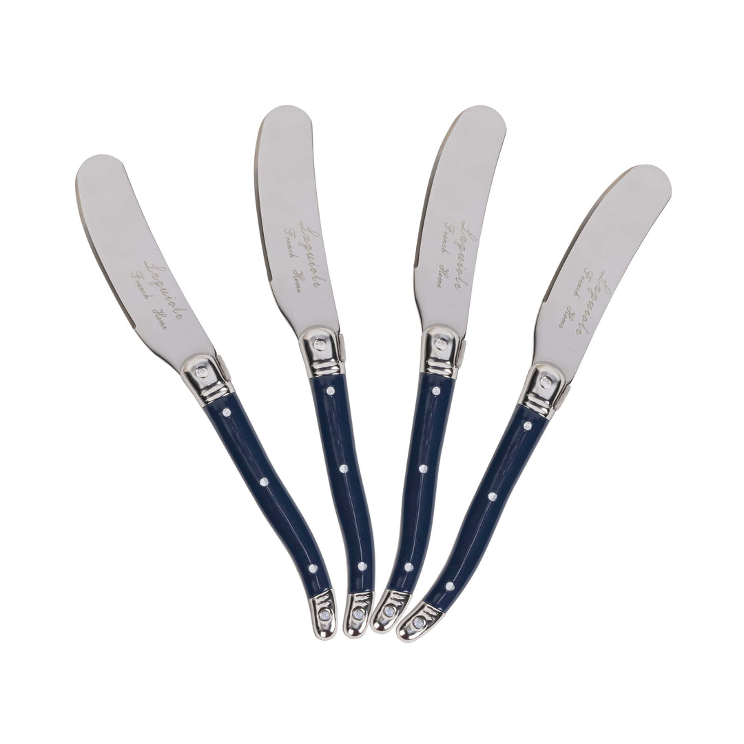 Four silver metal spreader knives with dark blue handles, arranged in a fan shape on a plain white background. Each handle features small white polka dots and a silver metal tip.