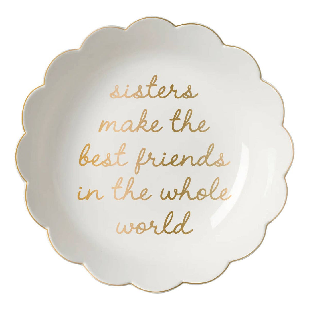 Decorative plate with gold text 'sisters make the best friends in the whole world' on a white background