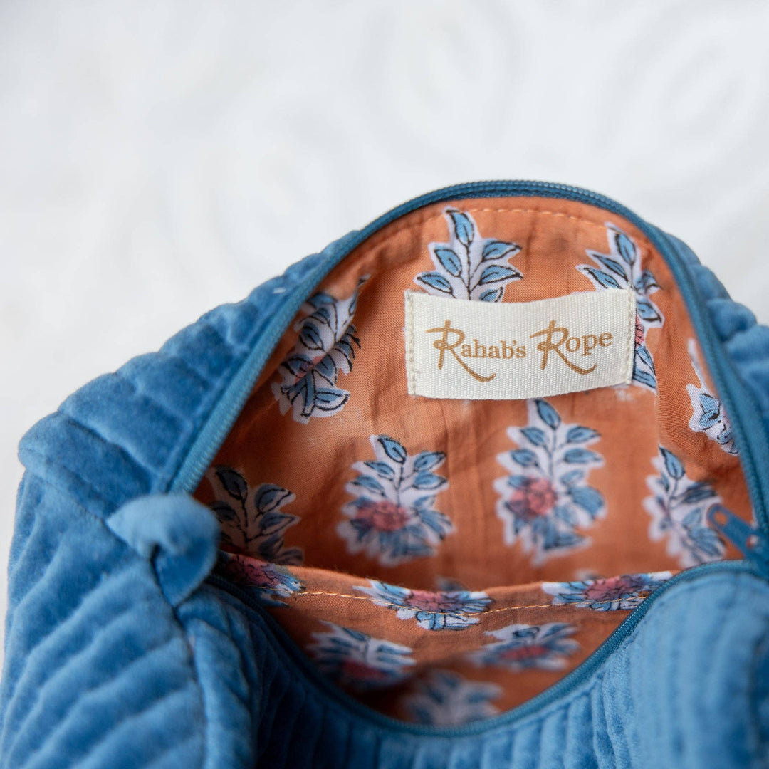 Blue textured fabric with floral patterned lining and 'Rabia Ropa' label on a white background