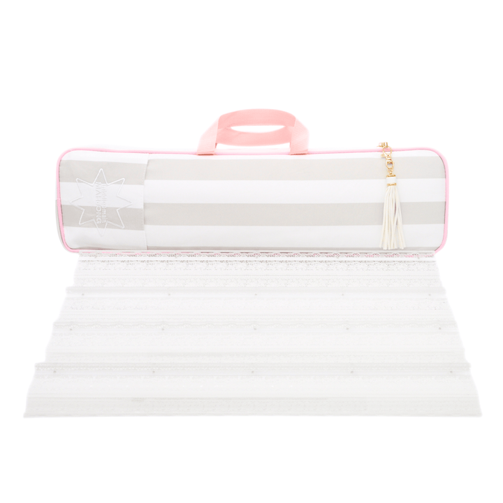 white and beige striped mahjong rack bag with a pink handle and tassel zipper pull, shown above its unfolded white textured surface on a white background.