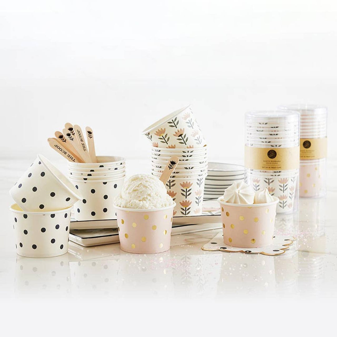 Set of paper cups and plates with floral and polka dot designs on a white background