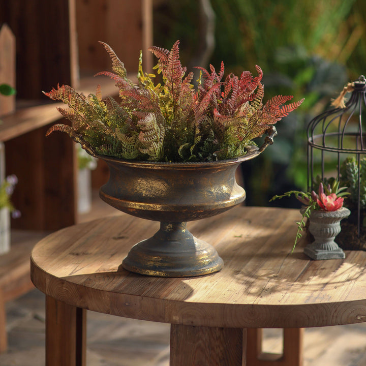 Decorative urn with ferns on a wooden table