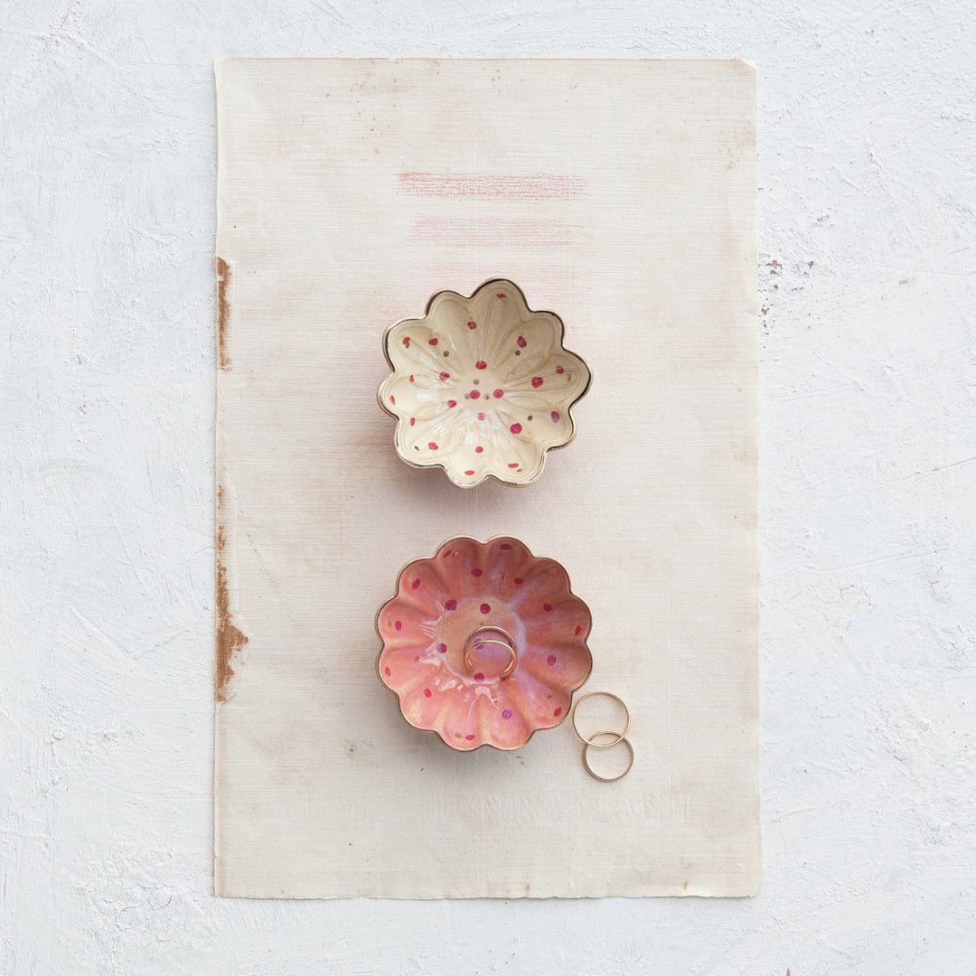 Two decorative ceramic bowls with floral designs on a textured surface