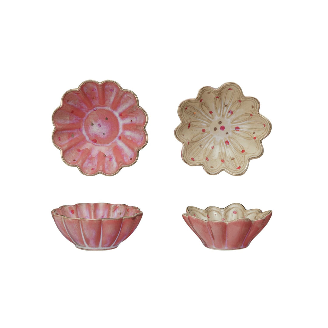 Set of four pink ceramic bowls with floral designs on a white background