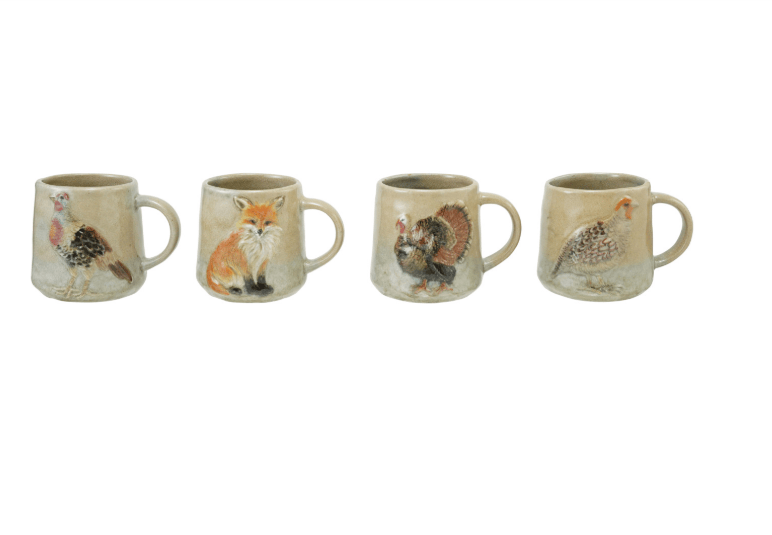 Four ceramic mugs lined up in a row, each decorated with a different animal illustration including a chicken, fox, turkey, and pheasant, on a plain white background.