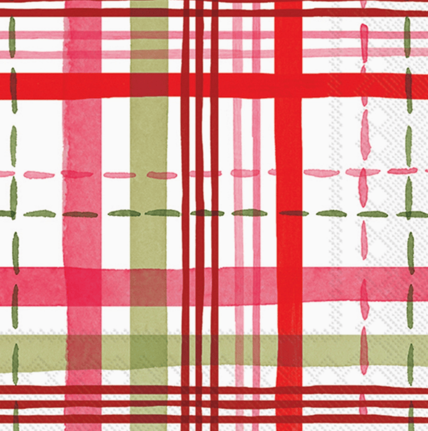 A close-up of a plaid patterned fabric or paper napkin featuring intersecting red, pink, and sage green stripes on a white background with stitched-looking dashed lines.