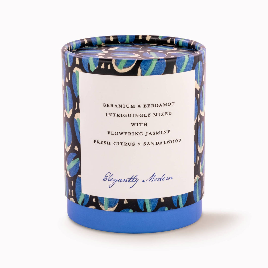 Candle with decorative packaging and label on a white background
