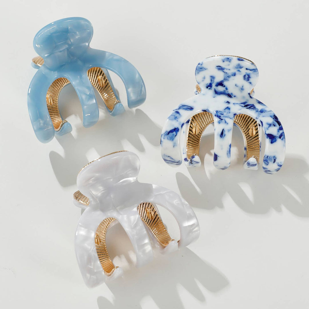 Three decorative hair claws with gold accents on a white background