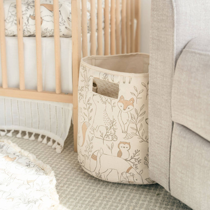Beige canvas basket with animal pattern in a nursery setting