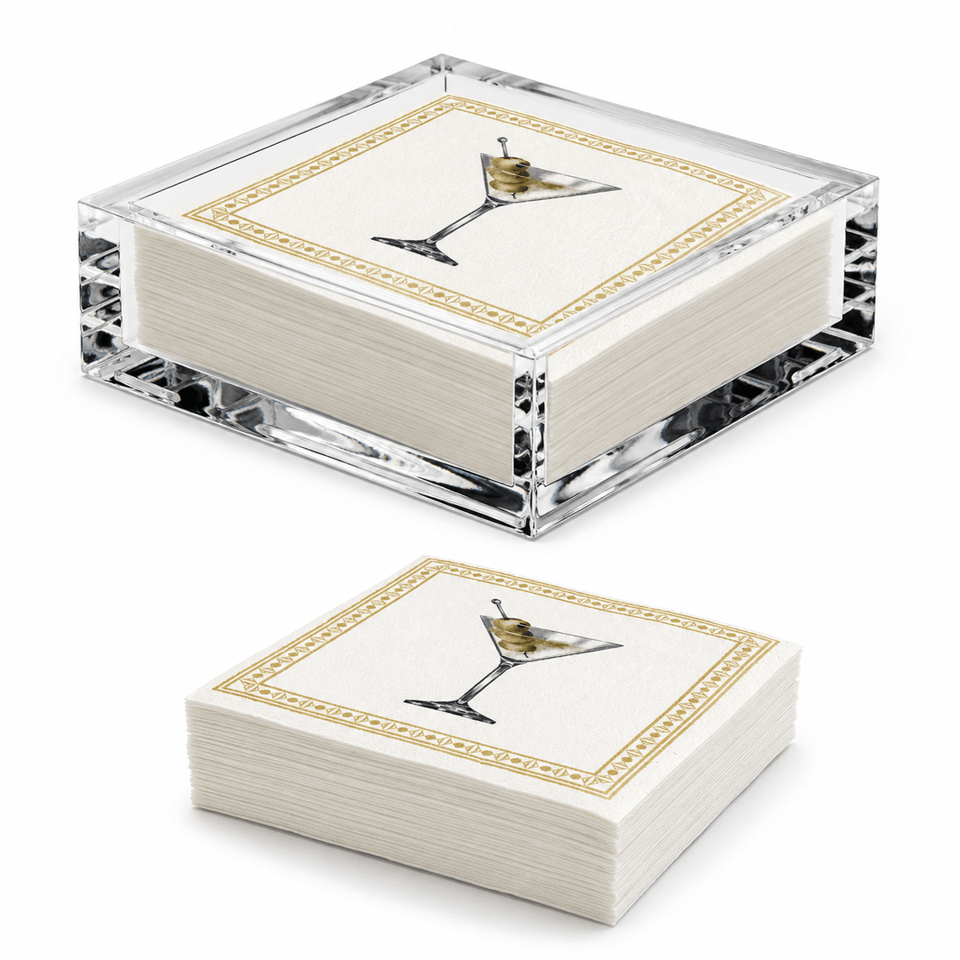 Two square stacks of white paper napkins in a clear acrylic holder, each printed with a martini glass illustration and a gold decorative border, shown on a white background.