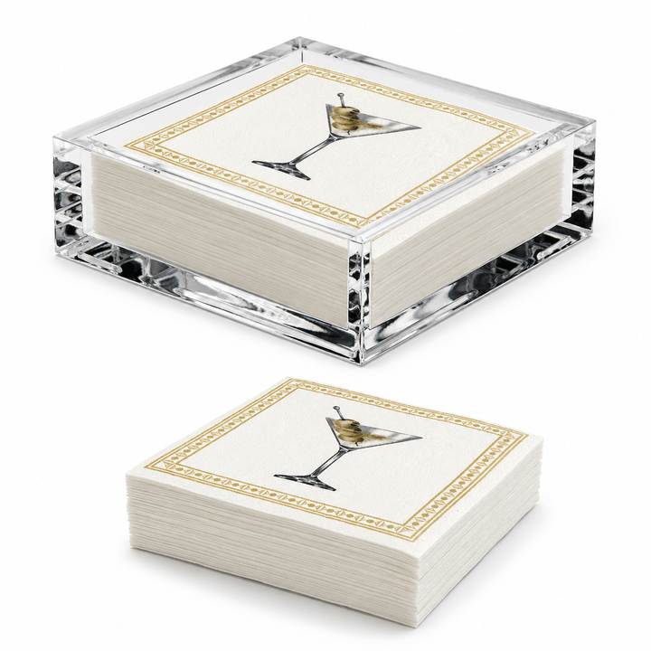Two square stacks of white paper napkins in a clear acrylic holder, each printed with a martini glass illustration and a gold decorative border, shown on a white background.
