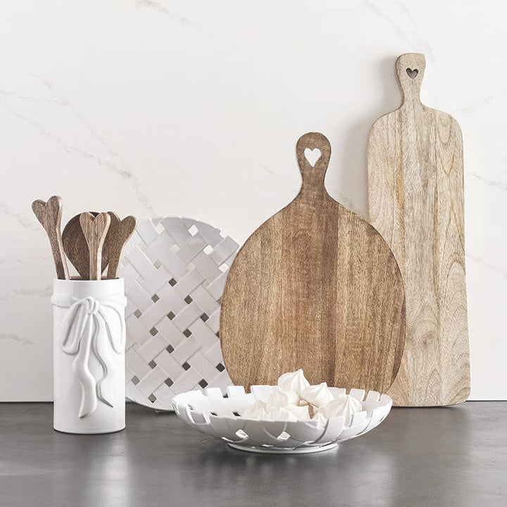 Set of wooden cutting boards and kitchen utensils on a neutral background