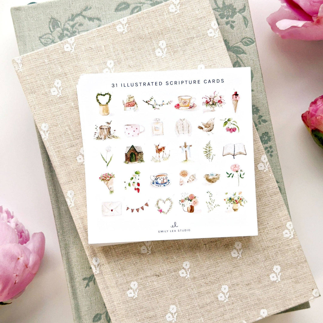 Set of illustrated scripture cards on a floral-patterned surface with pink flowers.