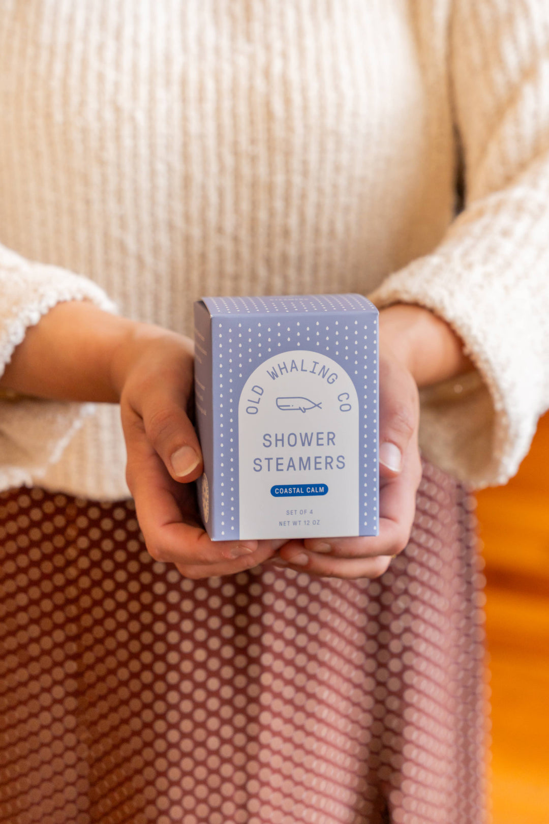 Person holding a box of Old Whaling Co. Shower Steamers