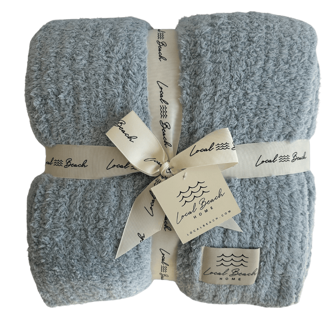 Two gray textured blankets tied with a ribbon and branded tags on a white background