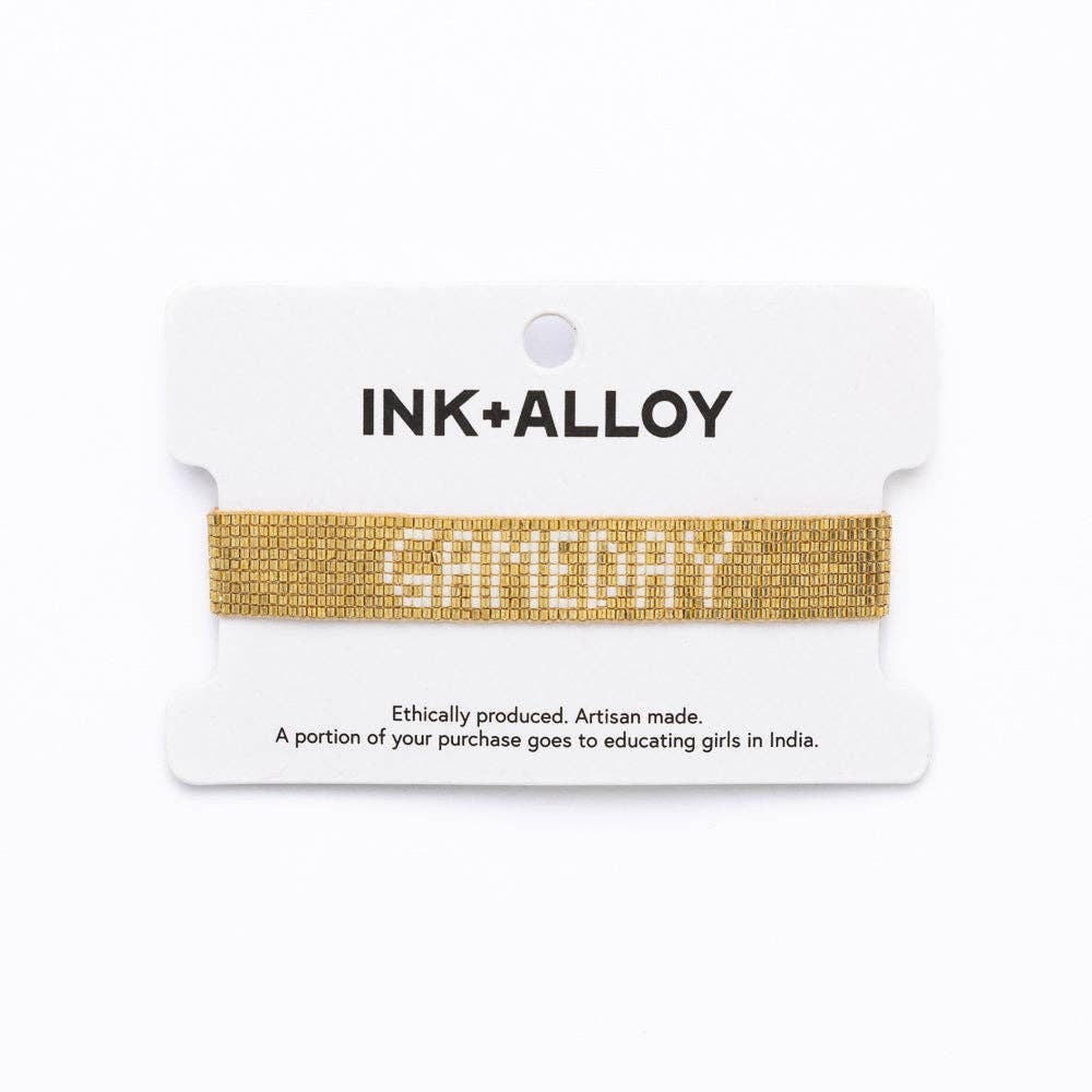 Gold bracelet on a white card with 'INK+ALLOY' branding