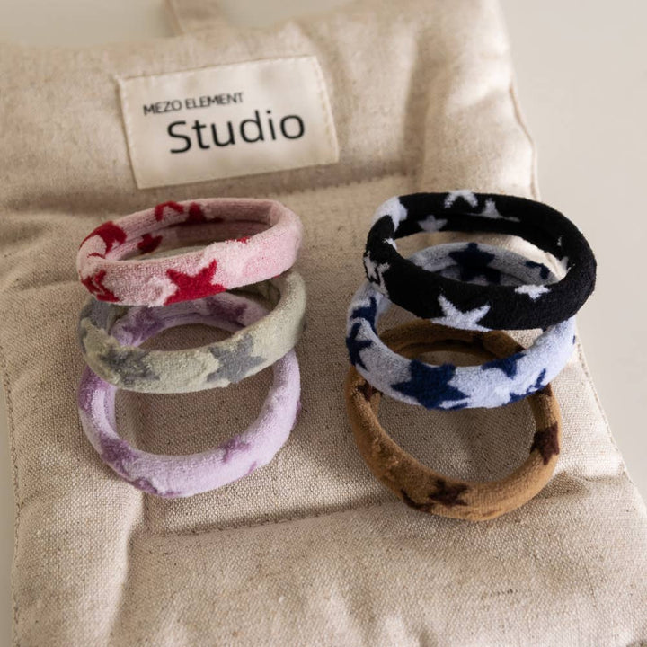 Set of colorful hair ties on a textured surface with 'MEZO ELEMENT Studio' branding.