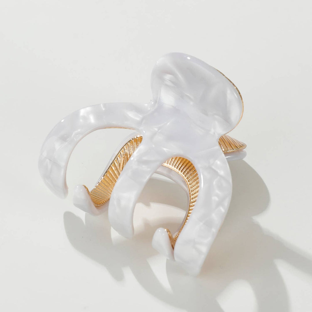 White and gold ring on a light gray background