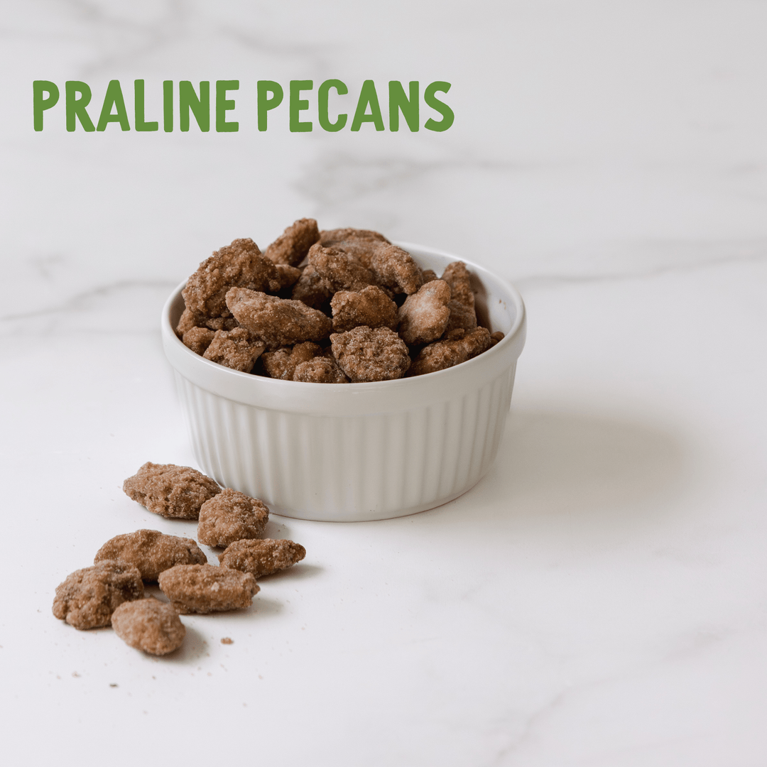 Praline pecans in a white bowl on a light background