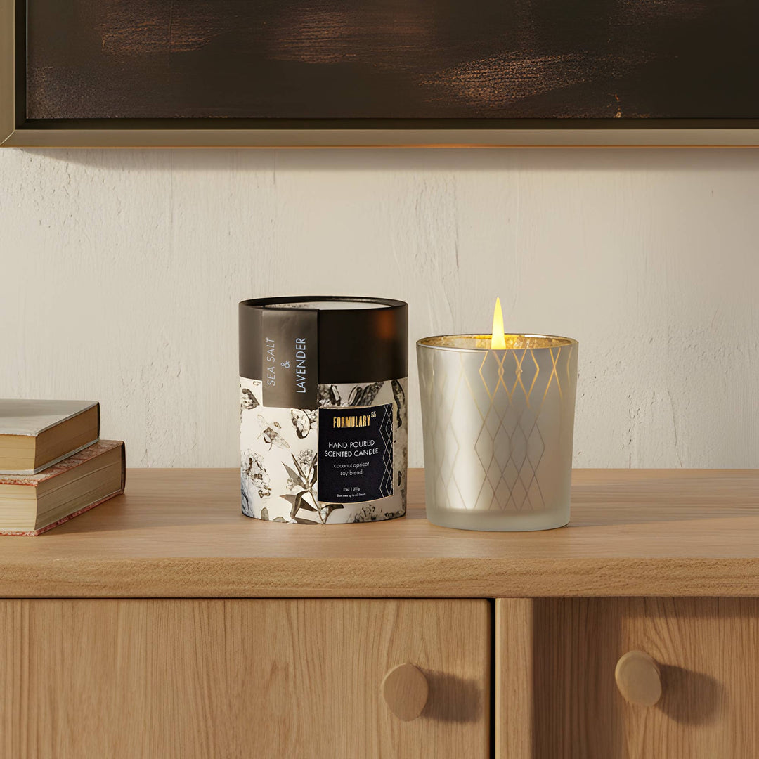 Candle and packaging on a wooden surface with a neutral background