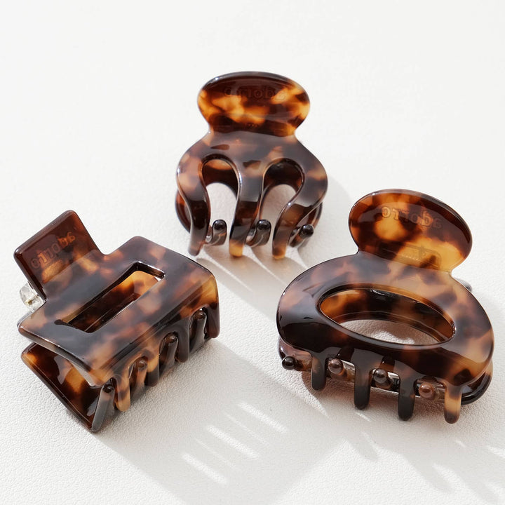 Three tortoiseshell hair clamps on a white background