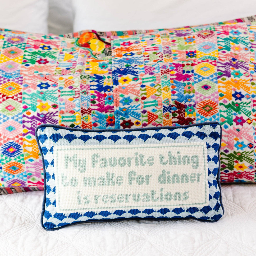 Colorful patchwork quilt with a decorative pillow featuring text on a white background