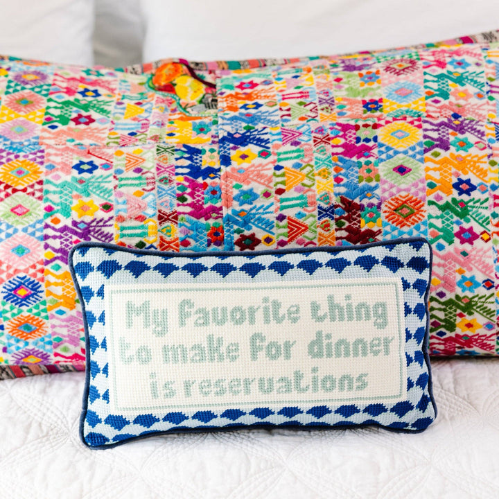 Colorful patchwork quilt with a decorative pillow featuring text on a white background