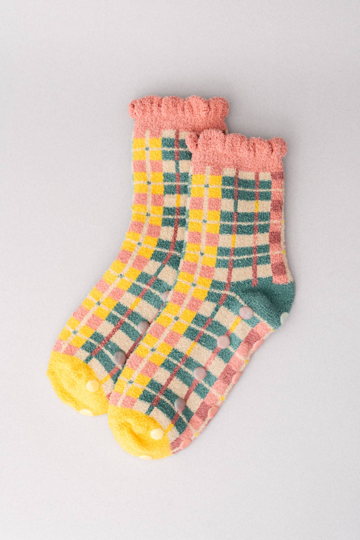 Pair of checkered socks with pink cuffs on a light gray background