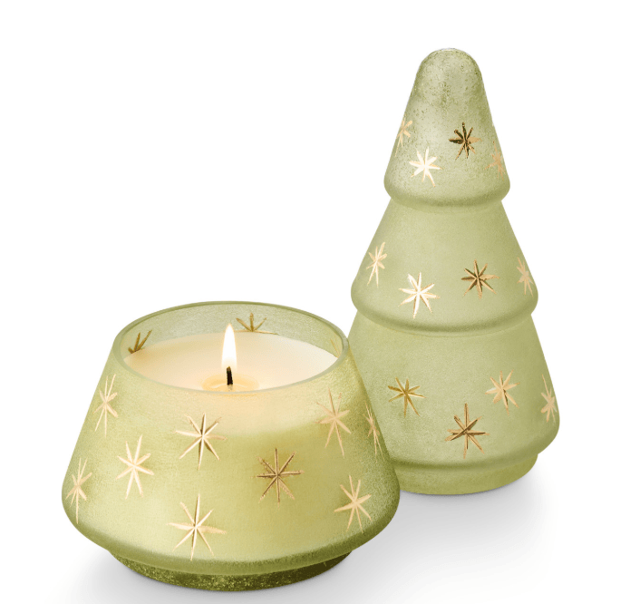 frosted light green holiday candles, including a lit candle in a flared holder and a matching tree-shaped candle holder with gold starburst accents, on a white background.