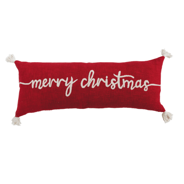 A rectangular red lumbar throw pillow with 'merry christmas' written in white cursive embroidery, finished with white tassels on the corners, shown against a plain white background.
