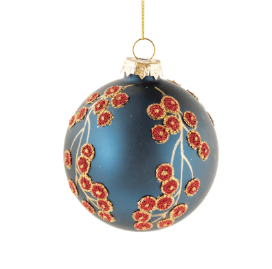 A dark blue glass Christmas ornament decorated with red and gold berry branches, hanging from a gold string against a white background.