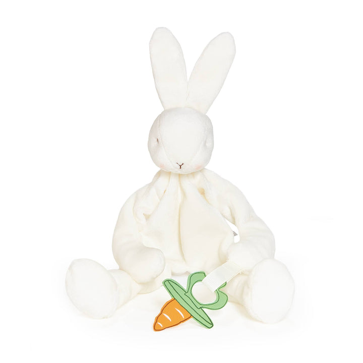 White plush bunny with a green pacifier and carrot on a white background