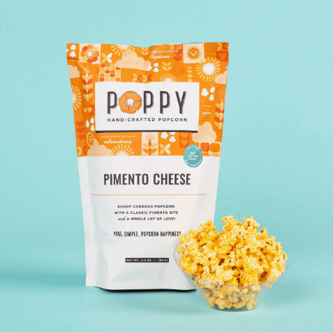 Poppy Hand Crafted Popcorn in pimeno cheese flavor on a light blue background