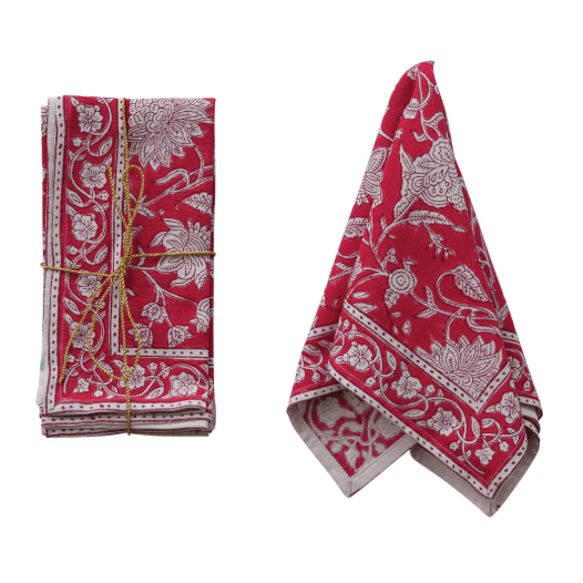A set of folded red and white patterned cloth napkins tied with gold string, displayed on a clean white background.